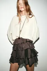 Minifalda marrón oscuro con tres capas de volantes y lentejuelas doradas aplicadas sobre la tela.
