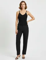 Top de punto acanalado negro, con escote en V y tirantes finos adornados con hebillas metálicas doradas.