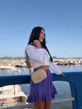 Bandolera de símil cuero color verde oliva, con diseño de dos compartimentos con cierre y correa ajustable de tela con patrón geométrico.