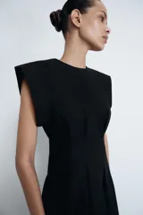 Vestido midi de Zara Woman Collection confeccionado en popelín de algodón. Presenta cuello redondo, manga corta y detalle de pliegues en la cintura que dan paso a una falda con caída evasé. Cierre posterior con abertura y botón.