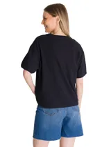 Remera negra de corte boxy y diseño liso, con cuello redondo y mangas cortas. Cuenta con un pequeño logo bordado en contraste sobre el pecho y parche bordado en la manga.