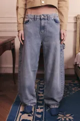 Jean de corte baggy y tiro bajo, en color azul lavado. Presenta un diseño holgado con presillas anchas en la cintura y estilo carpenter.