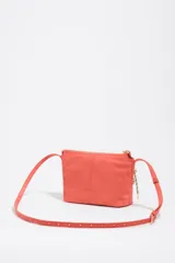 Bolso bandolera mini de Bimba y Lola en color negro, con cierre de cremallera superior, asas cortas de mano y tirador decorativo de cuerda con cuentas rojas. Presenta el logotipo de la marca impreso en letras doradas en la parte frontal.