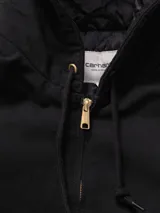 Campera Carhartt modelo OG Active, confeccionada en lona de algodón resistente, con diseño de corte holgado y silueta boxy. Presenta cierre frontal, capucha con cordones ajustables, bolsillos tipo canguro y puños y ruedo acanalados.