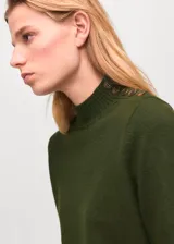 Jersey de punto medio color verde oscuro, diseño recto, cuello perkins y manga larga.