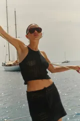 Minifalda negra tejida a crochet con cintura baja y cordón ajustable.