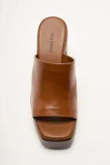 Zapato de plataforma tipo sueco, de empeine amplio en ante, con plataforma alta y taco ancho. Puntera cuadrada y diseño abierto en el talón.