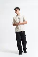 Remera negra de algodón con cuello redondo y estampado frontal con el logo de la marca Mistral y texto en blanco.