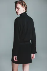 Pollera mini de tiro alto, confeccionada en tela lisa, con cierre lateral oculto y cinturón extraíble con hebilla metálica plateada.