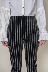 Pantalón negro de terciopelo con rayas verticales de lurex y cintura elástica.