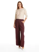 Pantalón tipo palazzo de corte ancho y fluido, confeccionado en tejido sastrero. Presenta tiro alto con doble abotonadura frontal, pinzas decorativas y cintura elástica en la parte posterior. Incluye bolsillos laterales funcionales.