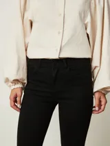 Pantalón de jean negro de corte flare, con tiro medio y bolsillos delanteros y traseros.