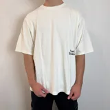 Remera color hueso con estampado de hongos y texto en la espalda, corte oversize.