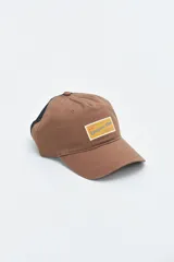 Gorra color marrón con visera curva y parche rectangular con texto "Uniform Club" en amarillo.