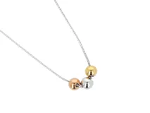 Collar de acero plateado con cadena de eslabones y tres dijes centrales en forma de bolitas: una plateada, una dorada y una color oro rosa.