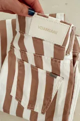 Pantalón jean de tiro bajo con estampado a rayas verticales color marrón y blanco.