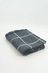 Poncho de tejido de punto con diseño de cuadros grandes en tonos azul y gris.