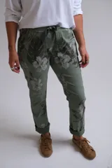 Pantalón de corte recto y tiro medio con estampado floral en tonos verdes. Presenta cintura elástica con cordón de ajuste, bolsillos laterales y dobladillo en los tobillos.