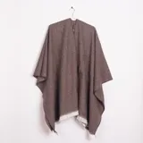 Ruana color marrón con tejido de espiga y flecos blancos en el borde inferior.