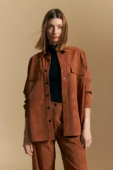 Sobrecamisa de efecto engomado en color negro, con textura lavada, cuello clásico, cierre frontal con botones a tono y bolsillos frontales con solapa.