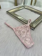 Pack de tres microtangas de encaje con diseño floral, cuentan con tiras laterales regulables y bordes con terminación en cinta elástica. El set incluye una prenda negra, una blanca con estampado floral negro y una beige con estampado floral negro.