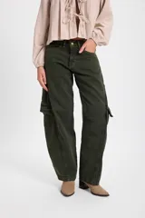 Jean estilo cargo de corte baggy, con pierna recta y ancha, color verde oliva. Presenta bolsillos laterales tipo cargo, costuras decorativas verticales y cierre frontal con botón metálico.