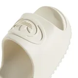 Ojotas de diseño deslizante color beige, con tira ancha en el empeine que presenta el logotipo del trifolio de Adidas en relieve.