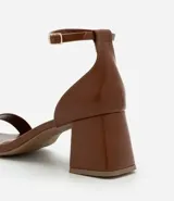 Sandalias negras de cuero sintético, con punta cuadrada, tira fina sobre los dedos, pulsera con hebilla al tobillo y tacón geométrico bajo.