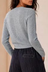 Sweater de punto celeste melange, con cuello redondo, manga larga y costuras decorativas frontales.