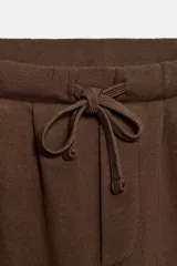 Pantalón balloon de algodón color crudo, con tiro medio, cintura elástica ajustable con cordón y bolsillos laterales.