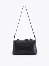 Cartera de hombro negra confeccionada en cuero vacuno, con diseño de solapa frontal decorada con volados de cuero y cierre metálico tipo candado.