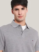 Chomba gris de corte regular, con cuello tipo chomba, cartera de dos botones, mangas cortas y logo de Tommy Hilfiger bordado en el pecho.