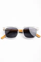 Lentes de sol polarizados con armazón transparente y patillas de madera, con cristales oscuros.