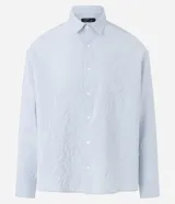 Camisa celeste de viscosa y poliéster con textura arrugada, cuello tradicional, manga larga y abotonadura frontal completa.