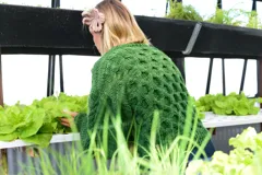 Sweater verde de lana merino, tejido a mano con punto panal y cuello a la base. Presenta mangas voluminosas con trenza central y puños muy anchos.