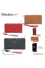 Billetera marrón con diseño acolchado en forma de V y cierre perimetral. Incluye correa de mano desmontable color fucsia y aplique metálico con forma de labio.