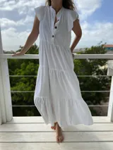 Vestido largo celeste de corte holgado, con cuello mao, mangas cortas y botones frontales.