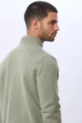 Buzo tejido de lana con cuello alto y medio cierre metálico frontal. Presenta puños y ruedo acanalados, con logo bordado en el pecho.