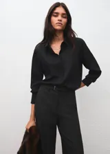 Pantalón de vestir negro de corte recto y tiro medio, con bolsillos laterales y trabillas para cinturón. Incluye un cinturón delgado a juego.