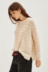 Sweater de punto con diseño calado geométrico, cuello redondo y mangas largas. Confeccionado en una mezcla de lana y alpaca, presenta una textura suave y ligera.