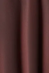 Vestido corto color marrón oscuro, con cuello alto y lazo frontal. Presenta mangas cortas abullonadas y una falda con vuelo y pliegues.