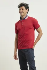 Chomba de piqué azul con cuello clásico, mangas cortas y corte recto. El cuello y los puños tienen detalles a contratono en azul marino y blanco.