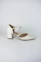 Sandalia de tacón cuadrado color blanco, con diseño de punta fina cerrada y tiras cruzadas ajustables con hebillas metálicas doradas.
