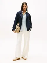 Pantalón estilo sastre, color blanco, confeccionado en piqué de mezcla de algodón y nylon. Presenta costura marcada en la parte delantera, cintura elástica y logo de Tommy Hilfiger bordado en fuente script en la pierna.