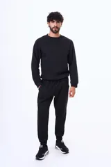 Buzo de felpa color negro, con cuello redondo, mangas largas y puños elásticos. Diseño básico y minimalista.