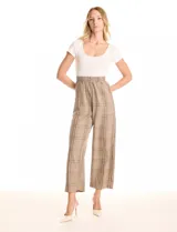 Enterito combinado de la marca Love & Piece. La parte superior es una remera blanca de manga corta y escote redondo. La parte inferior es un pantalón estampado a cuadros en tonos beige y marrón, con cintura elastizada y bolsillos inclinados en la delantera.