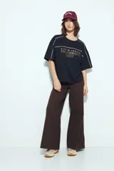 Remera negra de manga corta con estampado tipográfico "City of Angels California 1997" en tonos marrones y costuras visibles en blanco.