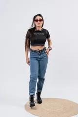 Jeans mom fit de tiro alto y lavado azul medio, con pernera relajada y dobladillo vuelto en los tobillos.