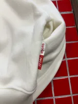 Hoodie de color blanco con capucha, corte holgado y estampado gráfico en la espalda con la frase 'MAKE MONEY NOT FRIENDS' en color negro.