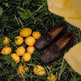 Mocasines de cuero marrón con textura símil reptil, horma de punta cuadrada y taco de madera foliado.